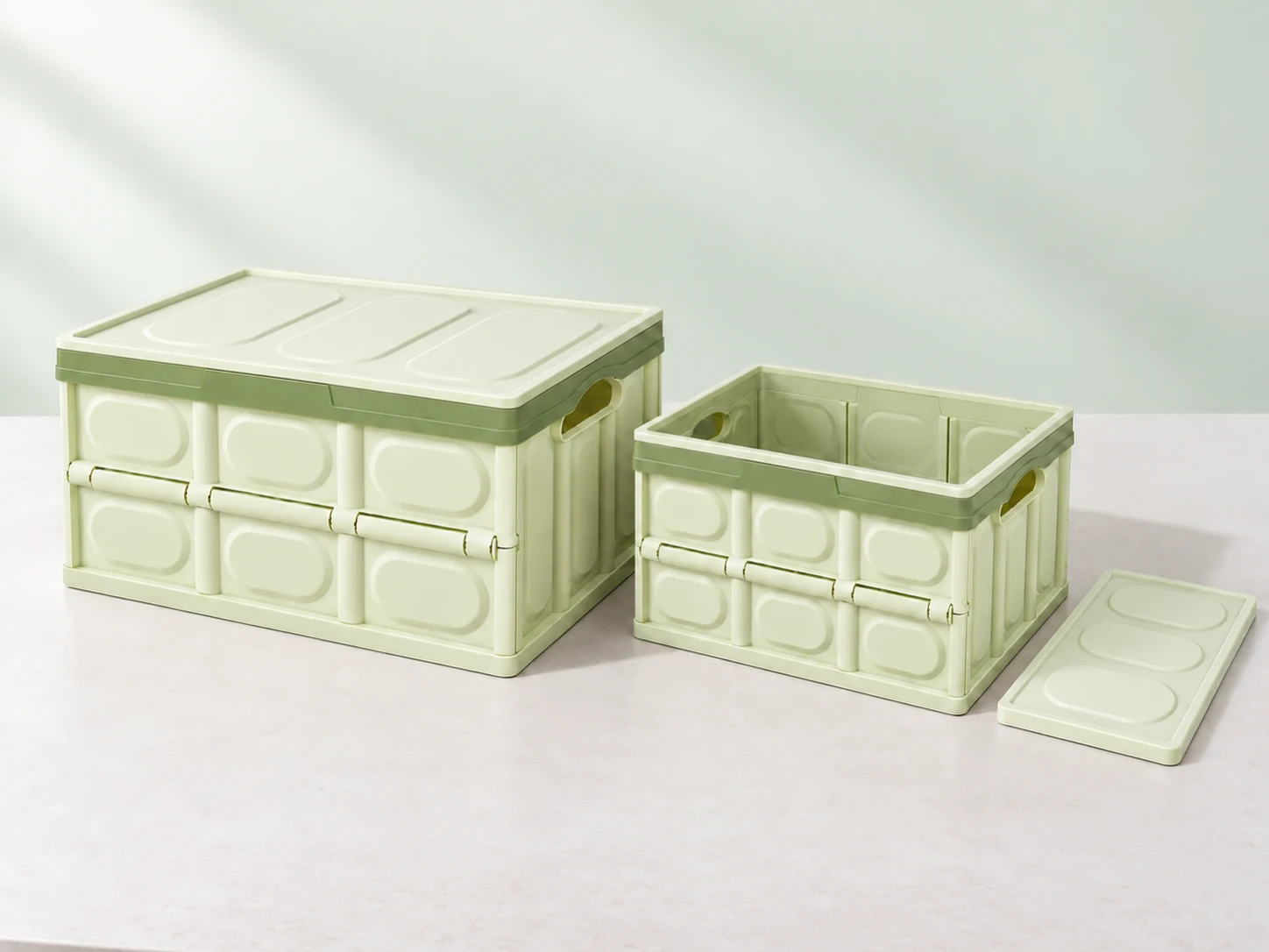 Illustration of two sizes of sage-green rigid folding boxes with matching lids